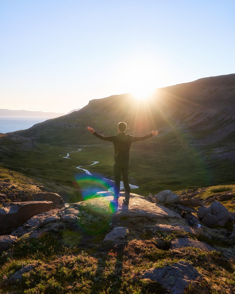 Hombre disfrutando del atardecer en los fiordos de islandia